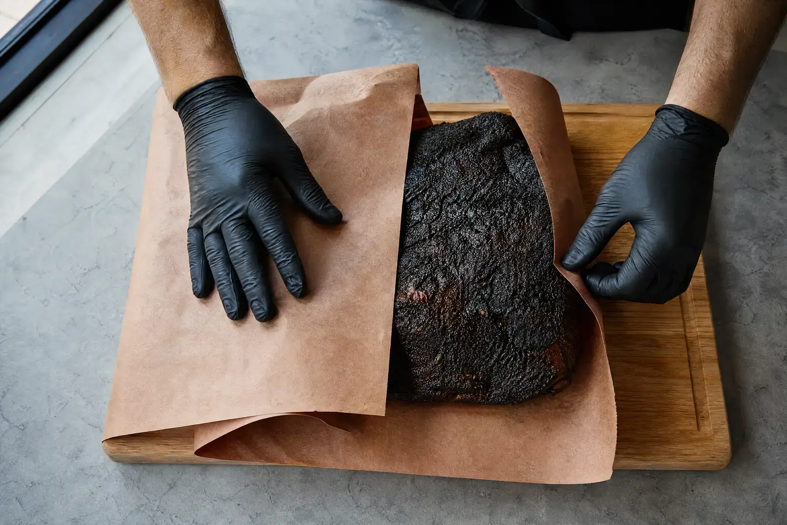 Brisket mit dunkler Kruste wird in unbeschichtetes Butcher Paper eingeschlagen